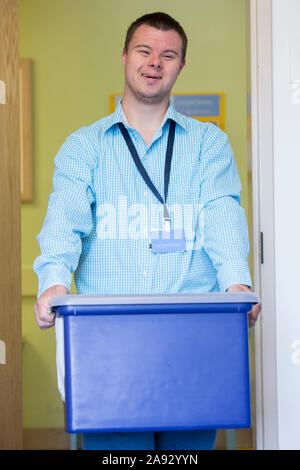 Man with Down Syndrome doing filing paperwork for a hospital Stock Photo