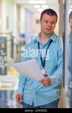 Man with Down Syndrome doing paperwork for a hospital Stock Photo