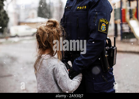 Police woman hugging daughter Stock Photo