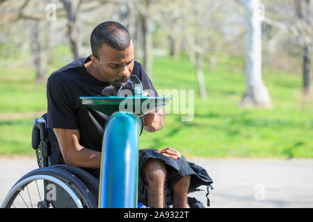 African American man with Cerebral Palsy using his cell phone at home Stock Photo