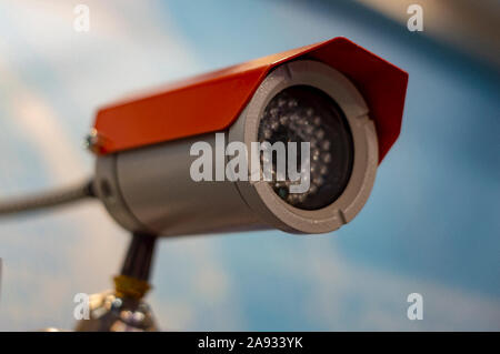 CCTV camera on blue background. Selective focus. Side view. Stock Photo