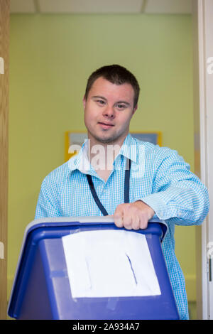 Man with Down Syndrome doing filing paperwork for a hospital Stock Photo