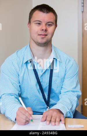 Man with Down Syndrome doing paperwork for a hospital Stock Photo