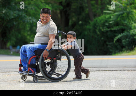 Hispanic man with Spinal Cord Injury in wheelchair with his son