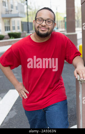 Portrait of happy African American man with Down Syndrome standing outdoors Stock Photo