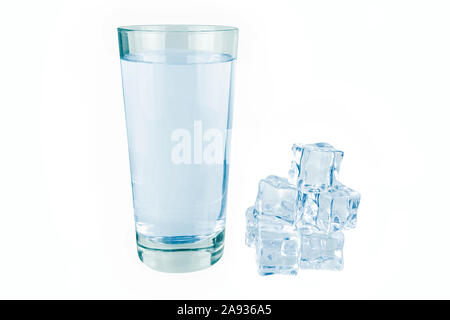 Glass of water next to lie ice cubes. Stock Photo