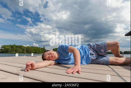 Young man with Down Syndrome playing on a dock Stock Photo