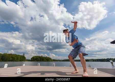 Young man with Down Syndrome playing on a dock Stock Photo