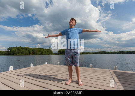 Young man with Down Syndrome standing on a dock Stock Photo