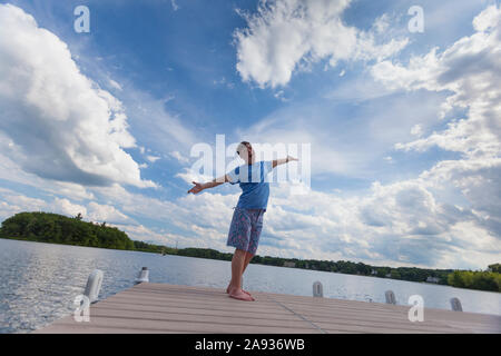 Young man with Down Syndrome playing on a dock Stock Photo