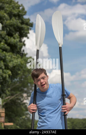Young man with Down Syndrome preparing to use a boat at a dock Stock Photo