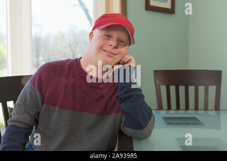 Portrait of a happy young man with Down Syndrome at home Stock Photo