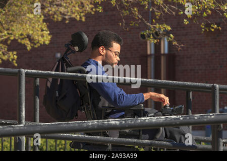 African American man with Cerebral Palsy using his power wheelchair outside Stock Photo