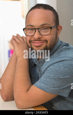 Portrait of happy African American man with Down Syndrome at home Stock Photo