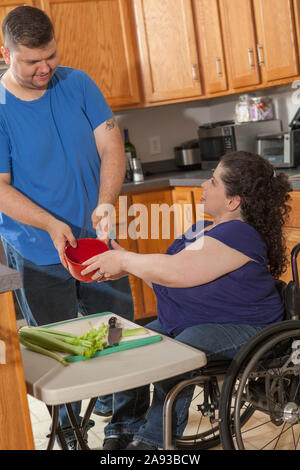 Woman with Spina Bifida and her husband preparing dinner in their kitchen Stock Photo
