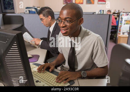 Two men with Autism working on computer in an office Stock Photo