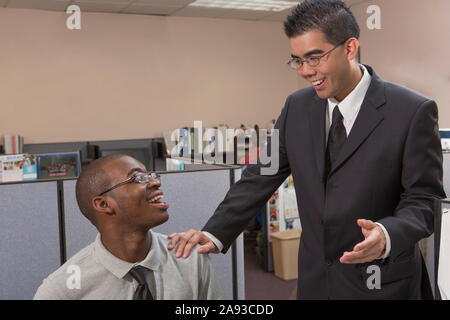 Two men with Autism talking and smiling in an office Stock Photo