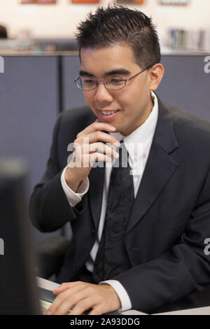 Asian man with Autism working on computer in an office Stock Photo