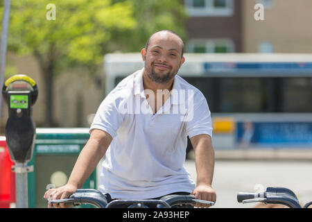 Man with Down Syndrome riding a bike Stock Photo