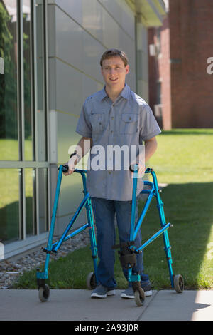 Young man with Cerebral Palsy using his walker to walk to work Stock Photo