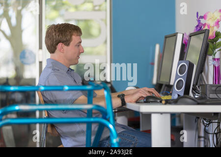 Young man with Cerebral Palsy working on his computer Stock Photo