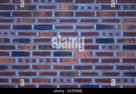 Decorative wall texture, background. Rusty and matted bricks. The fragment of a new decorative bricklaying. Multi-colored stylish exterior Stock Photo