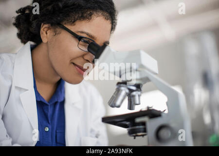 Scientist examining a sample through a microscope Stock Photo