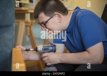 Man with Visual Impairment using a drill Stock Photo