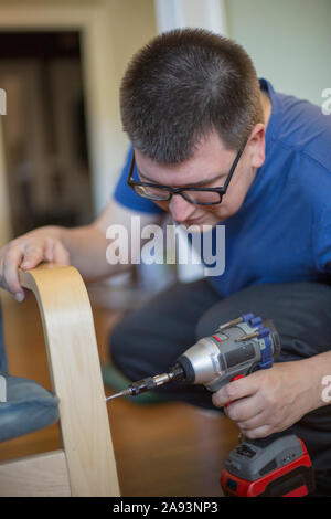 Man with Visual Impairment using a drill Stock Photo