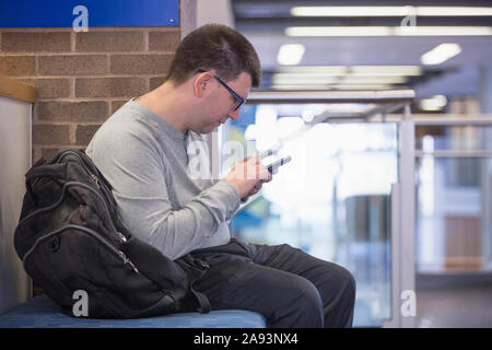 Man with Visual Impairment sitting at school and using his phone Stock Photo