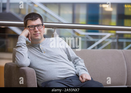 Man with Visual Impairment sitting on sofa at school Stock Photo