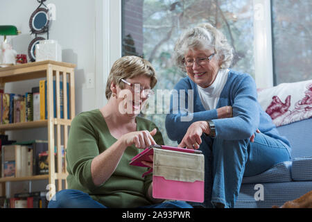 Woman with Autism using a digital tablet with her mother Stock Photo