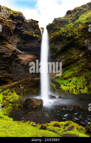 Kvernufoss waterfall cascading over mountain cliff and flowing motion of the river close to the Skogafoss waterfall in Southern Iceland Stock Photo