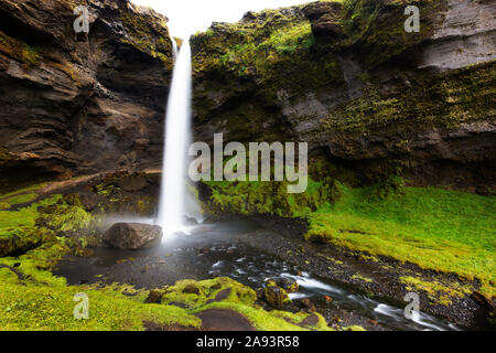 Kvernufoss waterfall cascading over mountain cliff and flowing motion of the river close to the Skogafoss waterfall in Southern Iceland Stock Photo