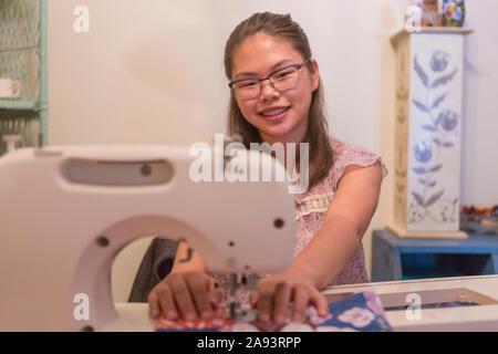 Teenage girl who has Learning Disability sewing clothes Stock Photo