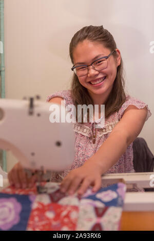 Teenage girl who has Learning Disability sewing clothes Stock Photo