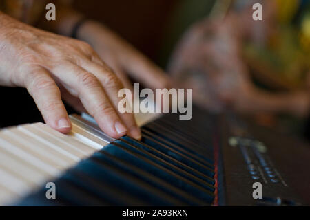 Man playing keys on an electronic keyboard. Stock Photo