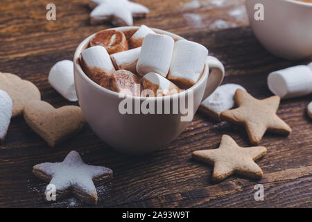 Hot chocolate, cocoa with marshmallows, star shape and heart shape Christmas cookies on the festive rustic wooden table, top view Stock Photo