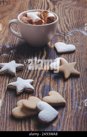 Hot chocolate, cocoa with marshmallows, star shape and heart shape Christmas cookies on the festive rustic wooden table, top view Stock Photo