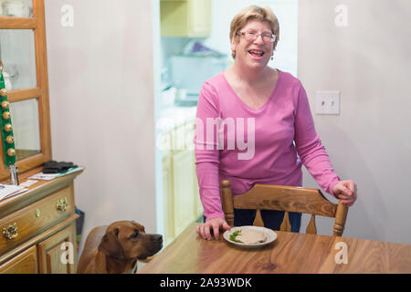 Woman with Autism standing near dining table and smiling Stock Photo