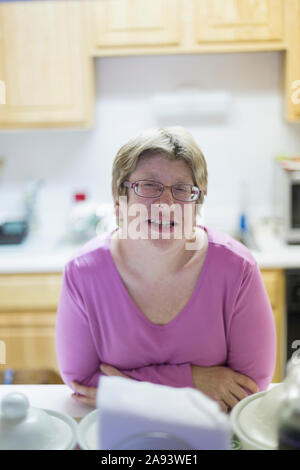 Woman with Autism smiling at dining table Stock Photo
