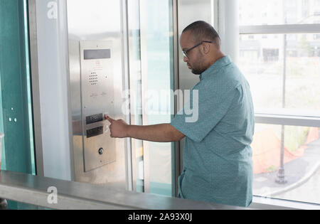 African American man who has Down Syndrome using an elevator Stock Photo