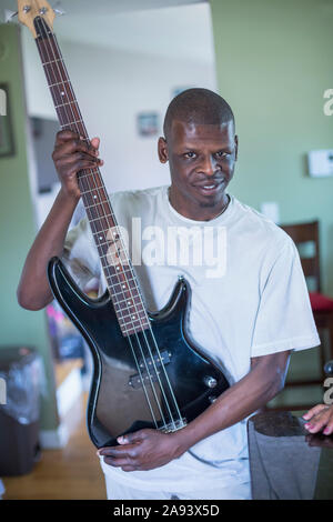 Man with Williams Syndrome playing a guitar Stock Photo