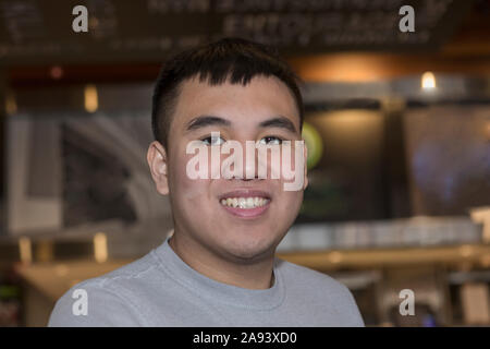 Young man with Autism working in a restaurant Stock Photo