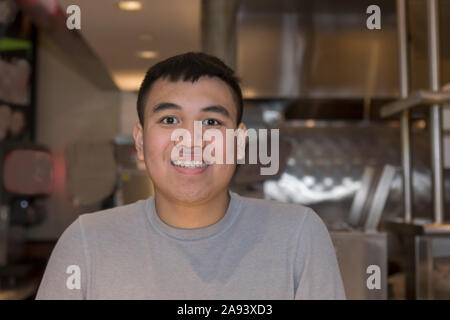 Young man with Autism working in a restaurant Stock Photo