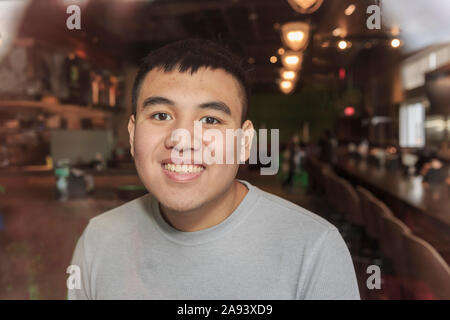 Young man with Autism working in a restaurant Stock Photo