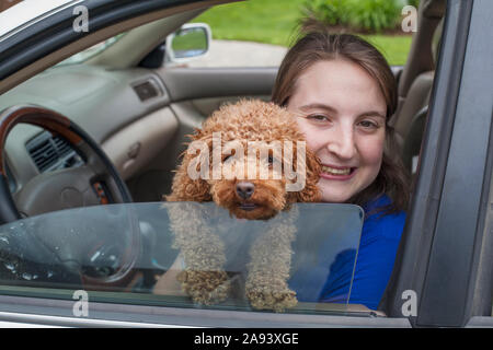 Young Woman with Cerebral Palsy holding her dog in the car Stock Photo