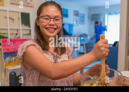 Teenage girl who has Learning Disability cooking Stock Photo