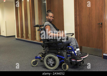 Teen with Cerebral Palsy in hallway of school Stock Photo