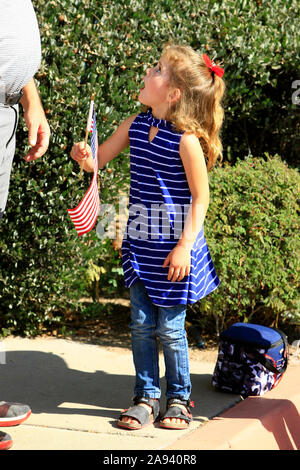 Young girl holding an American flag at the Veterans day parade in Tucson AZ Stock Photo